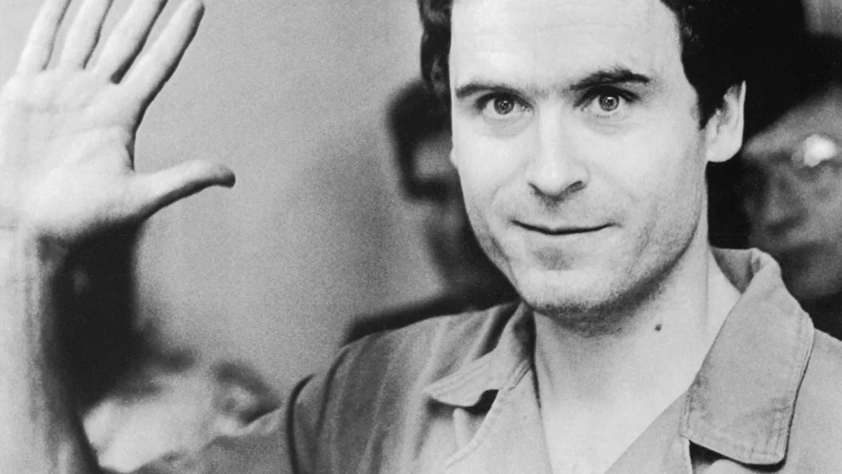 Ted Bundy saluant la caméra lors de l'un de ses procès